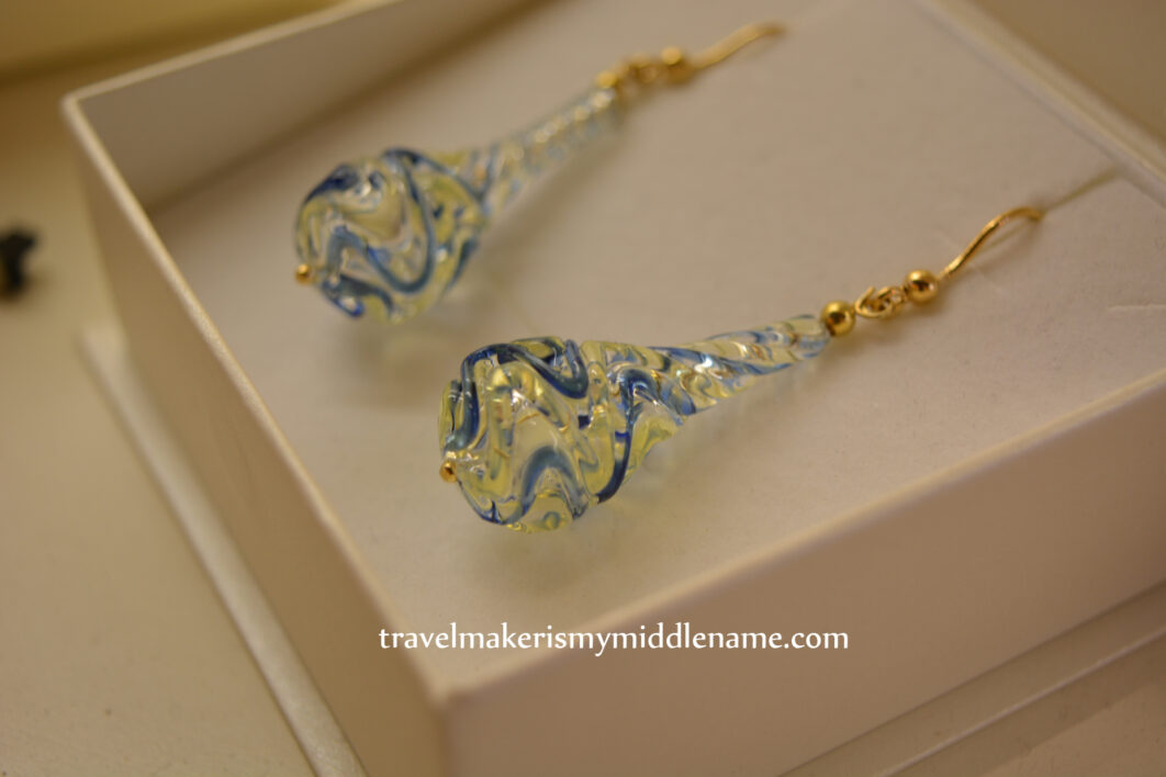 Long teardrop shaped glass earrings with blue squiggly lines and gold hooks. Photo copyright and credit: Author