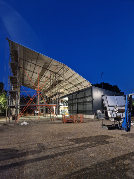 A view of the construction tent for building the parade floats at night.