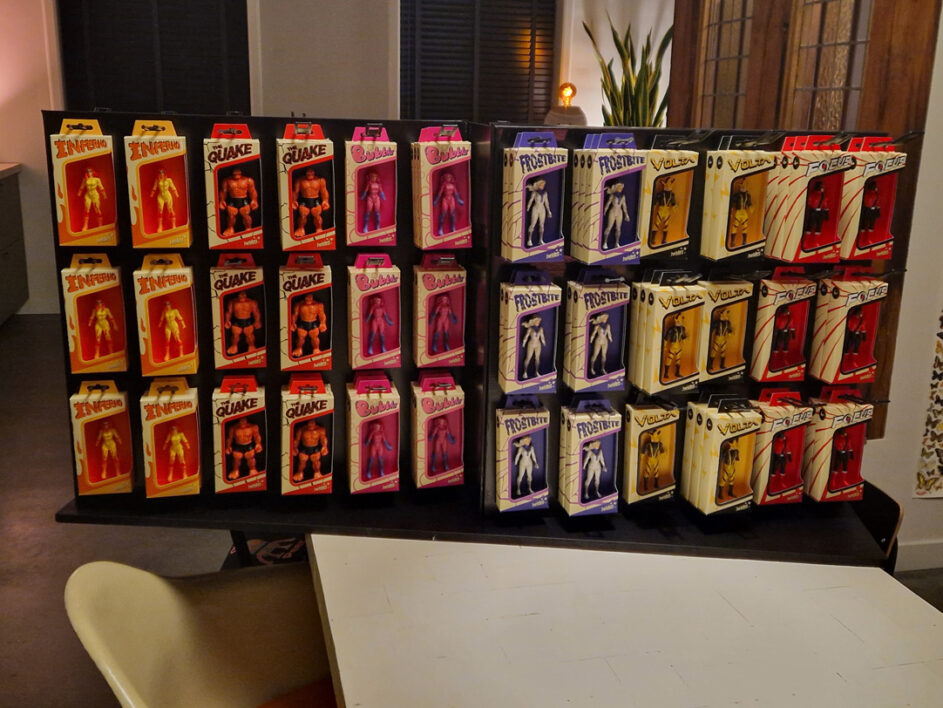 Rows and columns of boxes of hero figurines on a display wall.