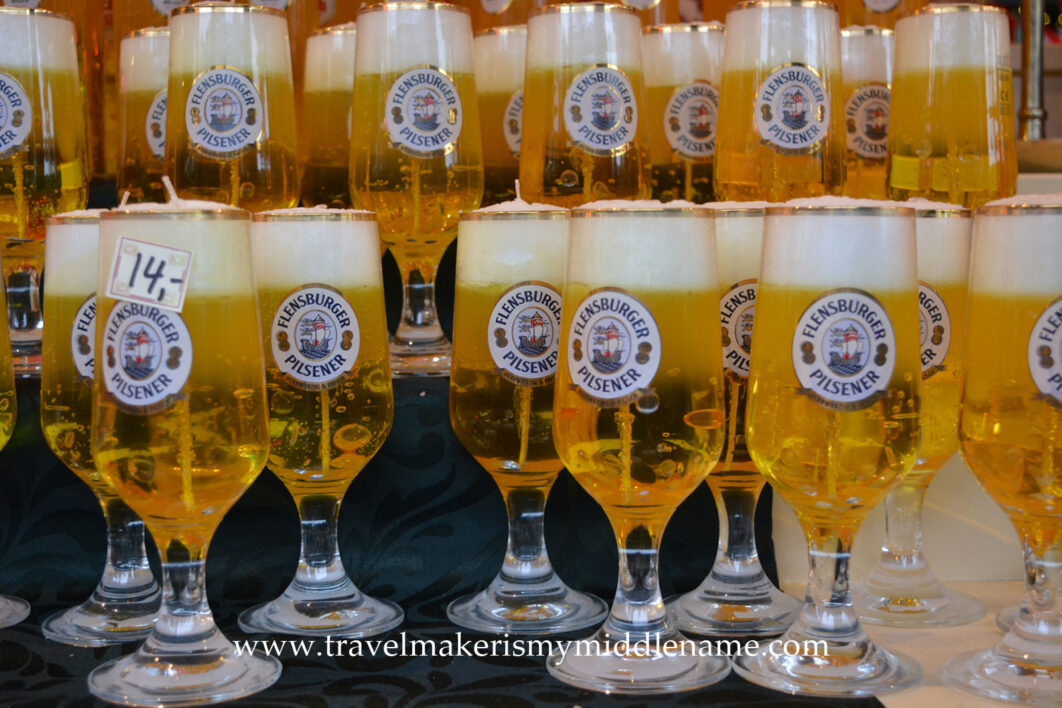 Flensburger beer shaped yellow candles in wine glasses