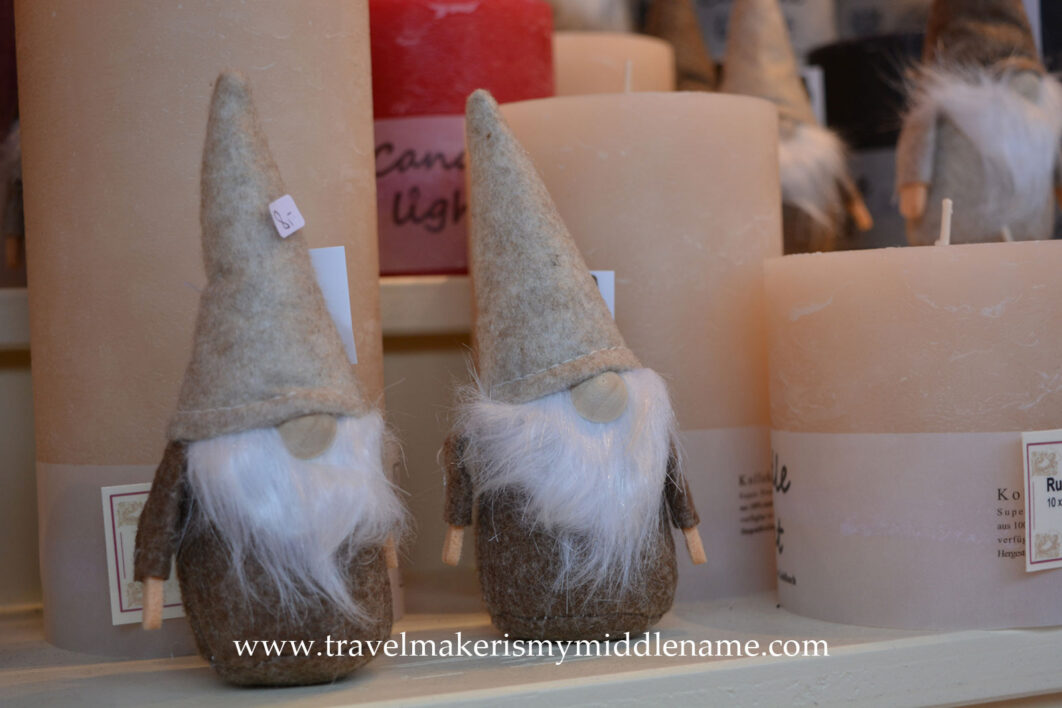 Candles and Nisse (Danish) or Wichtel (German) Christmas figurines with felt hats. They are small benevolent but prankster beings that look like gnomes with large round noses, white beards and a large pointy hat that is as talls they are, and covers their noses.