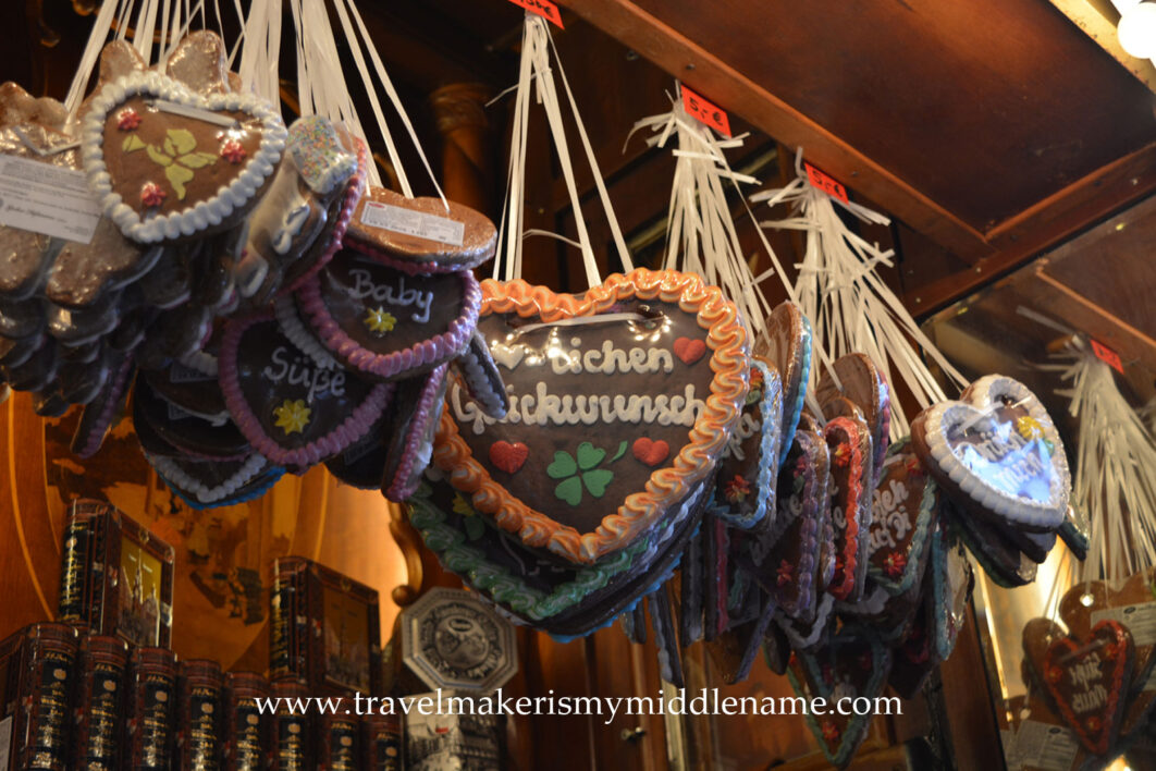 Giant gingerbread biscuits/cakes in the shape of love hearts hange from a roofline with well wishes written on them in German