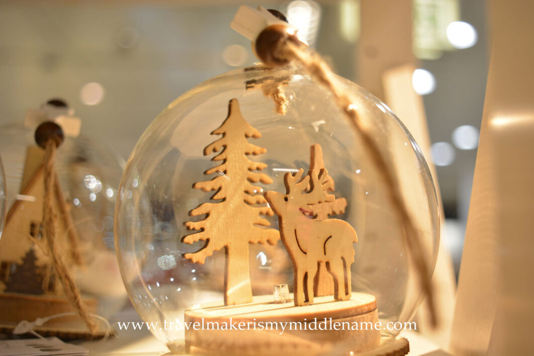 A light up clear glass bauble with a laser cut tree and reindeer inside from the shopping center