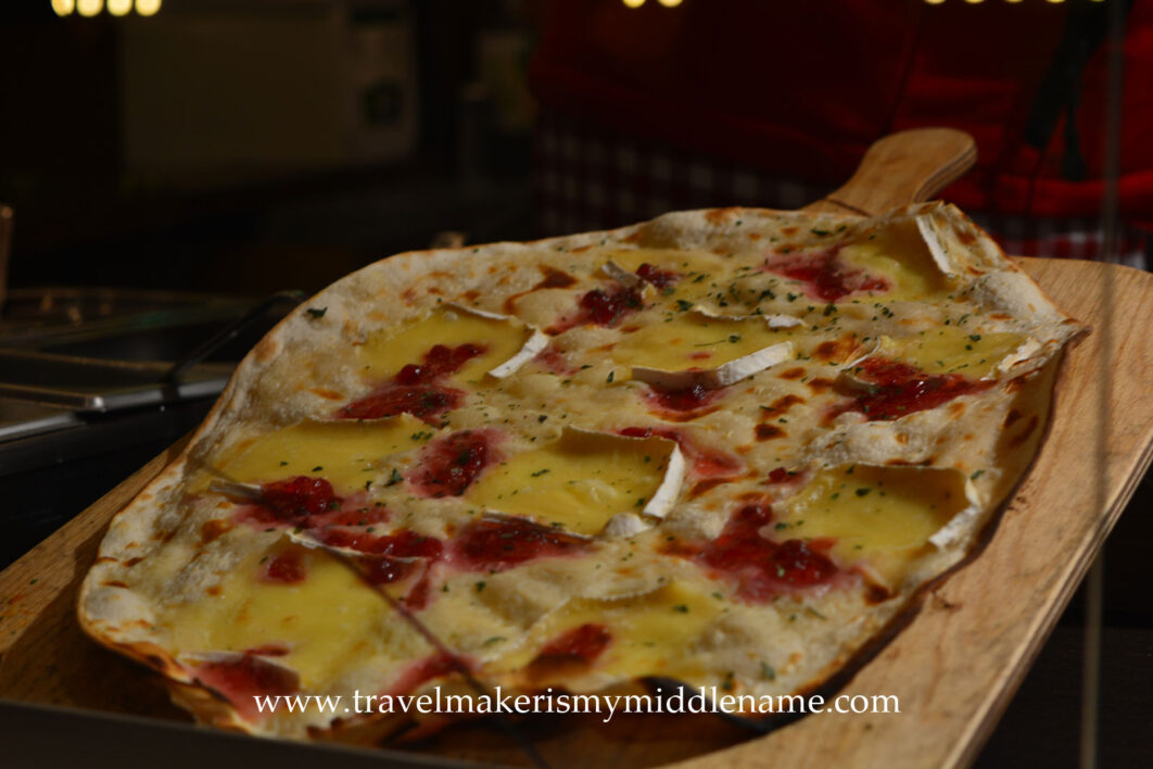 Flammkuchen, a German baked flatbread with toppings. This one has cheese and cranberries