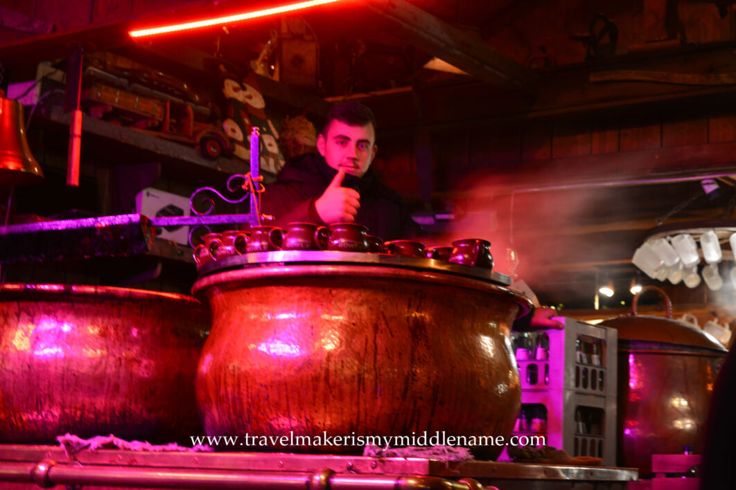 A happy glühwein stall holder gives a thumbs up to the camera