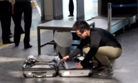 Person taking out a laptop at airport security. Photographer: Sedat Suna