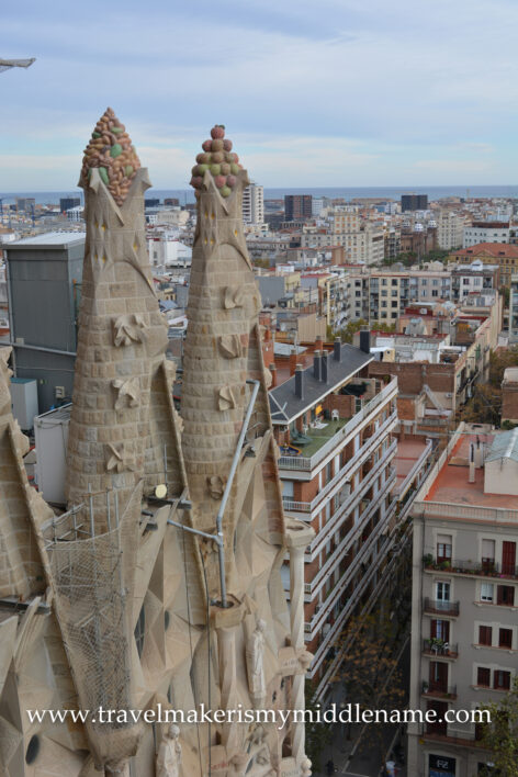 A view of some of the towers in La Sagrada Familia church in Barcelona, Spain and the nearby buildings, as seen from the top of the Passion tower.