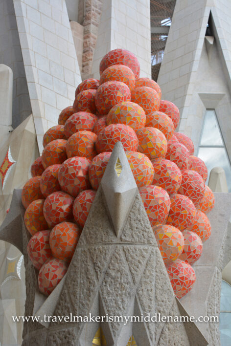A sculpture of a cluster of red-orange balls representing fruit in La Sagrada Familia church in Barcelona, Spain.