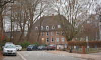 A brick building with a hip and gable roof, 11 Niemannsweg, UKSH campus.